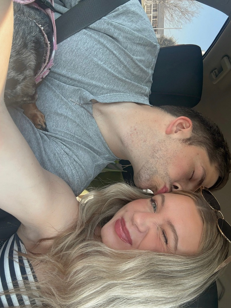 Kenny kissing Macie in the car with Coco along for the ride