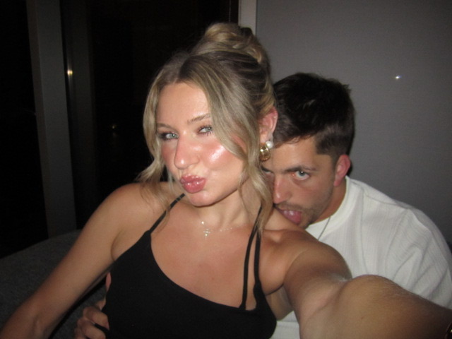 Macie making a kissy face with Kenny behind her