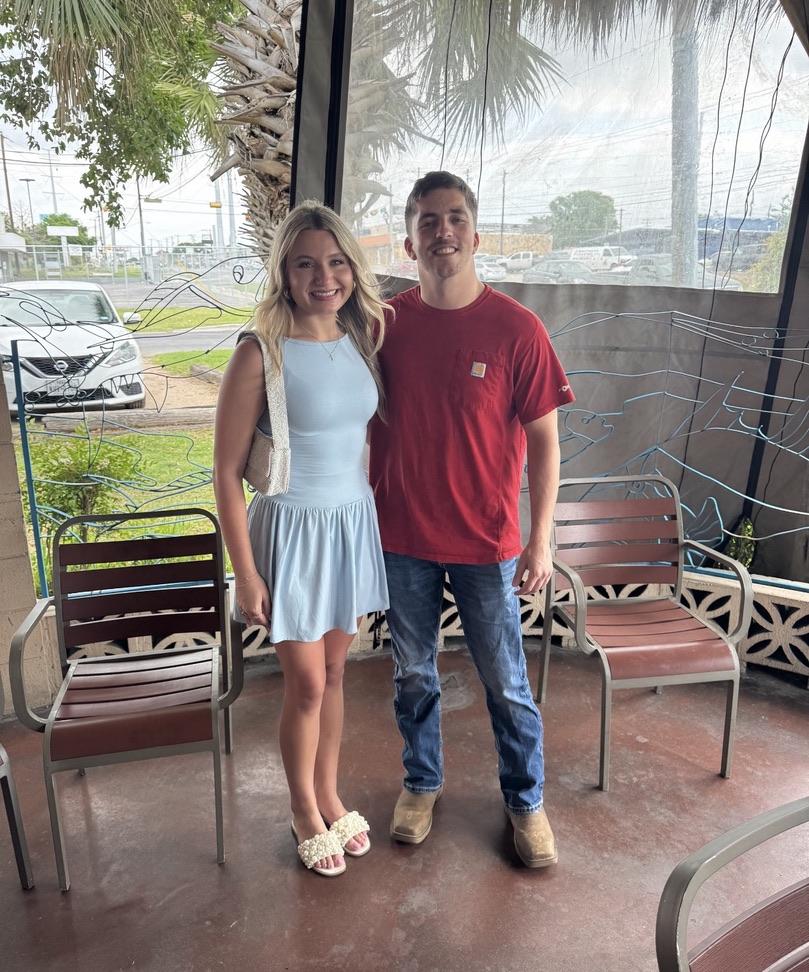 Macie in a light blue dress with Kenny on a patio