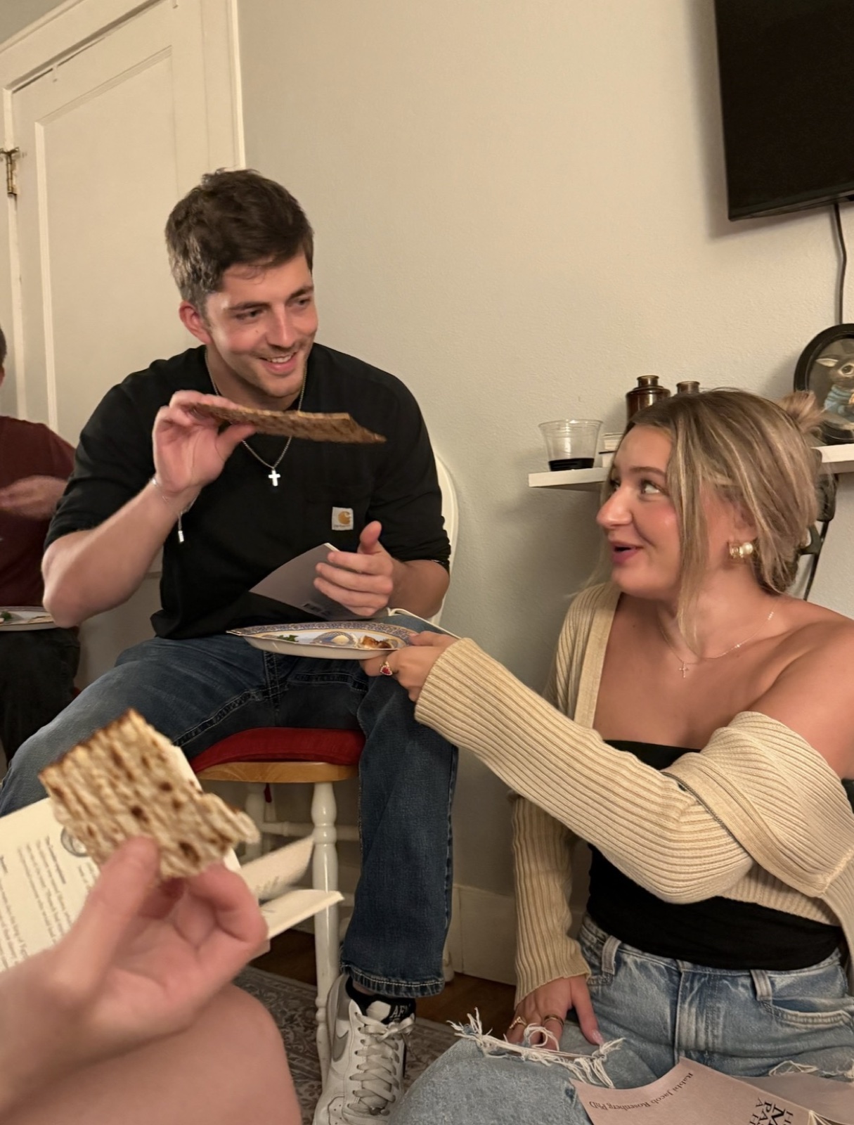 Macie and Kenny sharing matzah at a seder dinner