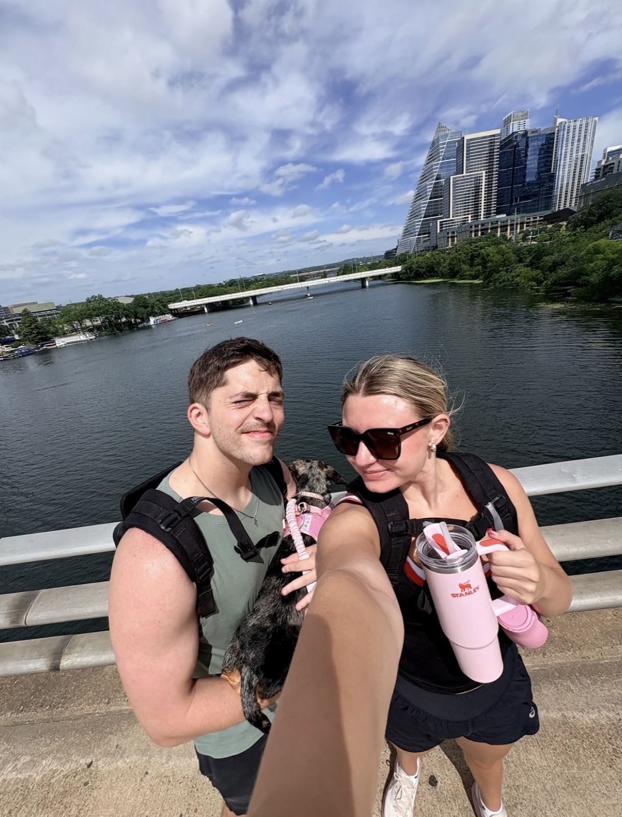Kenny carrying Coco on a sunny bridge walk with Macie